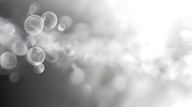 A blurry image of white and grey bubbles floating in the air. The bubbles are scattered throughout the image, with some closer to the foreground and others further away. Scene is one of whimsy