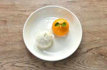 Chinese steamed bun stuffed sweet orange and salty chop pork on plate