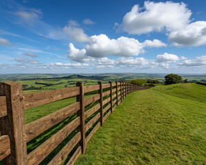 Fototapeta premium Rural property loan. scenic rural landscape with wooden fence under blue sky