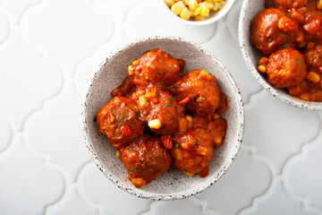 Homemade meatballs with hot sauce and corn