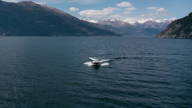 Aerial view of boat trip near Bellano, panoramic view from the drone to the famous old Italy town of Como lake. Near Varenna and Lierna, Bellano is a small town in Como, near Lecco, in Lombardia.