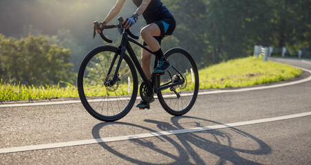 Woman cyclist riding bike in summer park