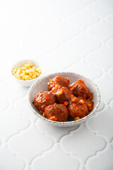 Homemade meatballs with hot sauce and corn