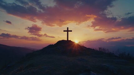 Holy concept: A silhouette of the cross on top of the hill with an on-mountain sunset beautiful sky background, the concept for Easter and Jesus Christ.