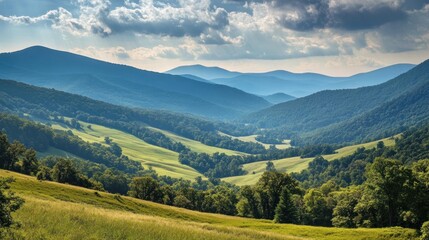 Obraz premium Rolling green hills and hazy mountain ranges under a dramatic cloudy sky