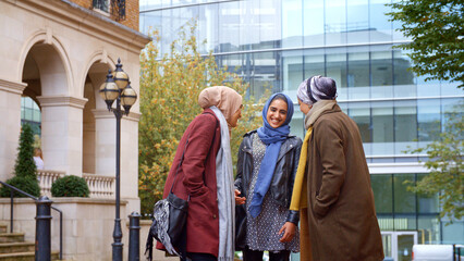 Fototapeta premium Group Of Young British Muslim Businesswomen Meeting And Talking Outside Office