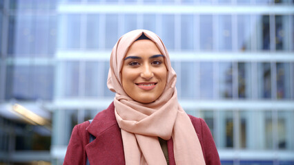 Portrait Of Smiling Young British Muslim Businesswoman Wearing Hijab Outside Office