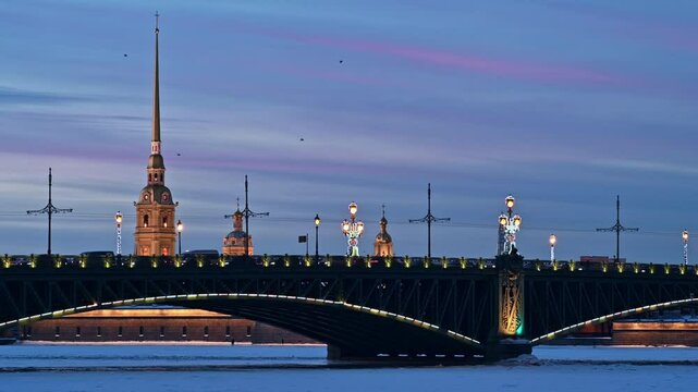 Saint-Petersburg, Russia, winter. Troitsky bridge lit with lanterns in twilight and Peter and Paul cathedral in background.  City traffic.