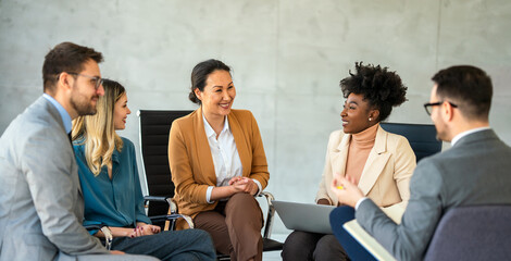 Multicultural professional businesspeople working together on research plan in boardroom.