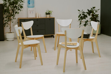 Arranged chairs in a modern office space with minimal decor and indoor plants adding an earthy touch creating a cozy and inviting atmosphere