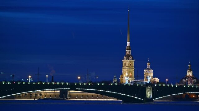Saint-Petersburg, Russia, winter. Troitsky bridge lit with lanterns in twilight and Peter and Paul cathedral in background.  City traffic.