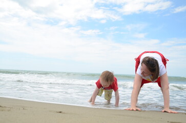 Mother and son playing on the shoreline. Summer enjoyment