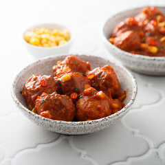 Homemade meatballs with hot sauce and corn
