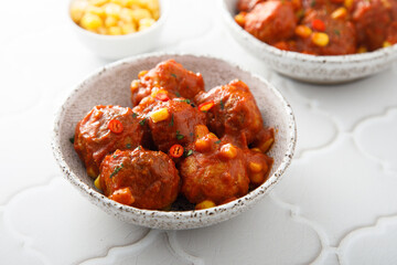 Homemade meatballs with hot sauce and corn