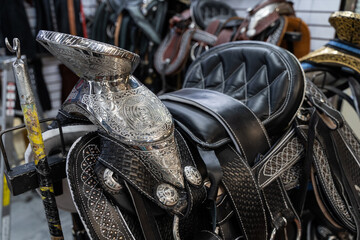 Silver and black leather riding saddle at store in Mexico. Horseriding equipment concept