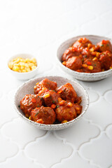 Homemade meatballs with hot sauce and corn