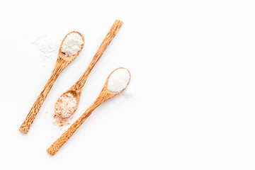 Different kind of sea salt in wooden spoon, top view. Salt for spa, salt baths or cooking