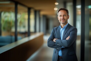 portrait of successful senior businessman consultant looking at camera and smiling inside modern office building