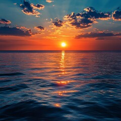 Obraz premium A stunning sunset over the sea, with the sky painted in warm colors and the sun sinking below the horizon.