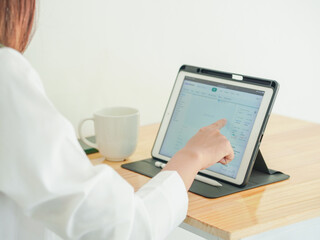  Businessman looking at stock chart on laptop screen. Asian businesswoman working on stocks and...