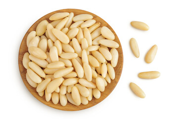 Shelled European pine nuts in wooden bowl isolated on white background with full depth of field....