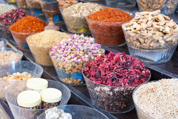Traditional spices market. Pots and wooden tubs stand in row with colorful tea, spices, fruits, roots, flowers. Street bazaar.