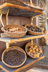 Traditional spices market. Pots and wooden tubs stand in row with tea, spices, fruits, roots, flowers. Street bazaar.