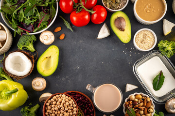 Plant based keto food background with low carb vegan keto diet ingredients, healthy vegetarian fat and protein source. Assortment green vegetables, nuts, legumes, oil, coconut, nuts, peanut butter