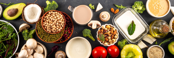 Plant based keto food background with low carb vegan keto diet ingredients, healthy vegetarian fat and protein source. Assortment green vegetables, nuts, legumes, oil, coconut, nuts, peanut butter