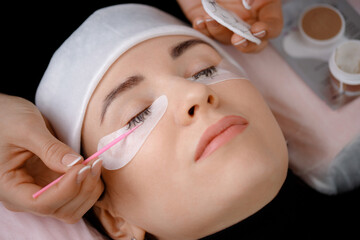 Young caucasian female undergoes eyelash removal beauty procedure in salon setting