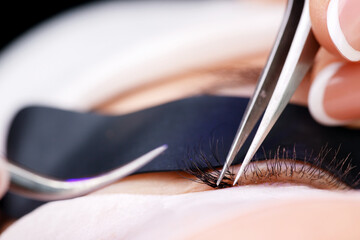 Female eyelash extension procedure with led ultraviolet light for beauty enhancement, macro photo