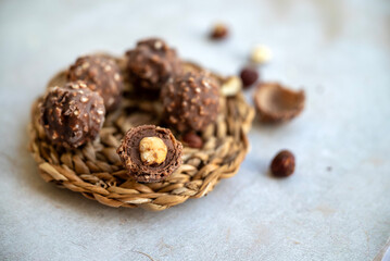 Chocolate candy truffles with hazelnuts on shadows  background