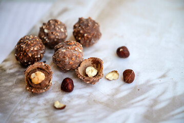 Chocolate candy with hazelnuts on shadows  background