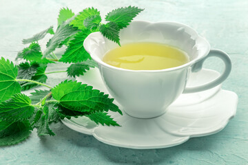 Nettle tea. Medicinal herbal tea with Urtica leaves. Fresh wild herb, an elegant white cup