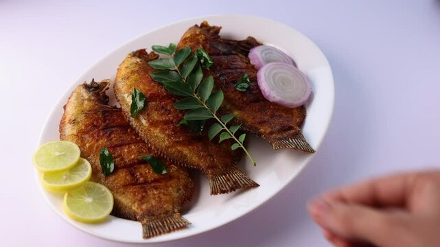 Kerala fish curry, Karimeen Pollichathu a popular hot and spicy baked fish in banana leaves Alleppey India. pearl spot fish is marinated with Indian spices then wrapped in plantain leaf and grilled.