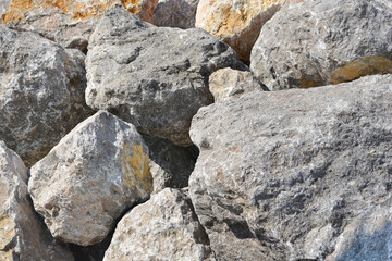 A close-up view of a pile of large, gray rocks next to a breakwater