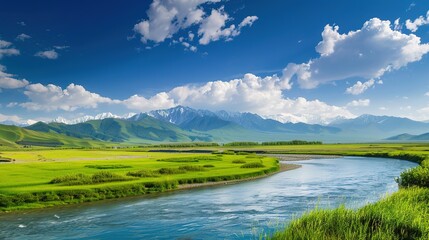 A beautiful green field with a majestic mountain, a clear river and a vast sky in the background. The idyllic and serene natural scenery creates a peaceful and charming atmosphere.