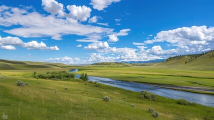 Fototapeta premium A beautiful green field with a majestic mountain, a clear river and a vast sky in the background. The idyllic and serene natural scenery creates a peaceful and charming atmosphere.