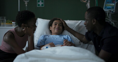 African father and mother sit in a hospital room next to their daughter who is being treated for a...