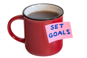 czerwony kubek z herbatą z przyklejoną kartką samoprzylepną z napisem: SET GOALS