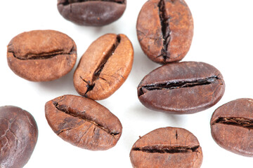 Coffee beans falling in the air isolated on a white background. roasted coffee beans cutout. Close-up of roasted Arabica coffee beans.