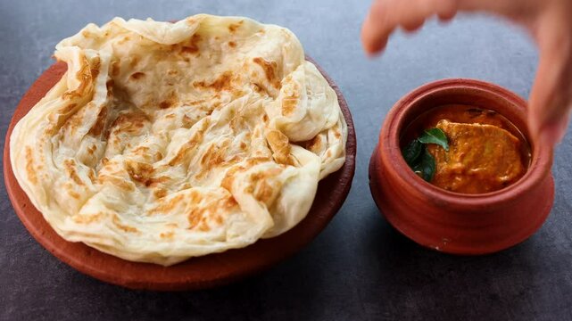 Fish curry with Kerala parathas porotta roti parotta barotta naan layered flatbread made from maida whole wheat flour. Eat with spicy Asian chicken beef egg curry gravy. Indian food