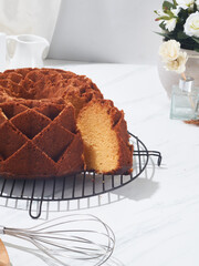 Honey cake is freshly baked and cooling on a rack with a slice removed, enhancing the inviting kitchen atmosphere filled with decor
