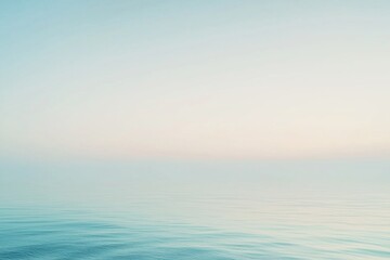 Obraz premium Serene ocean view at dawn with gentle waves and soft pastel colors reflecting in the sky