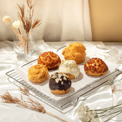 An enticing display of assorted cream-filled pastries rests on a decorative plate, complemented by delicate floral arrangements