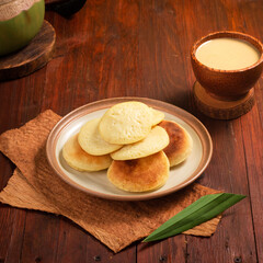 Pancakes are neatly arranged on a rustic plate, alongside a smooth, creamy beverage in a unique cup, creating a cozy atmosphere