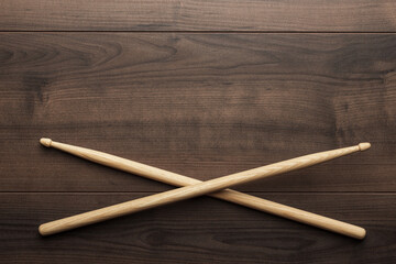 Flat lay top down photo of pair of wooden drumsticks on wooden table with copy space.