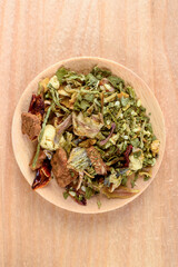 Top view of dried herbs and spices for instant noodles on wooden plate.