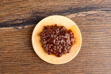 Top view of instant noodle sauce on wooden serving plate.