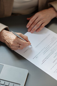 High angle of hands of unrecognizable experienced director of business company signing contract in office